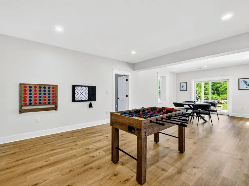 Game Room - Foosball takes center stage with wall-size Connect 4, giant Scrabble, and ring toss, and a lakeside table just beyond the sliding doors.
