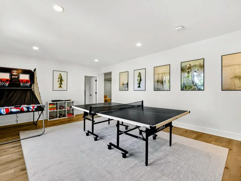 Game Room - Ping pong and Pop-A-Shot anchor the lower level beneath a gallery of lake-and-fish art, with room enough for a tournament.