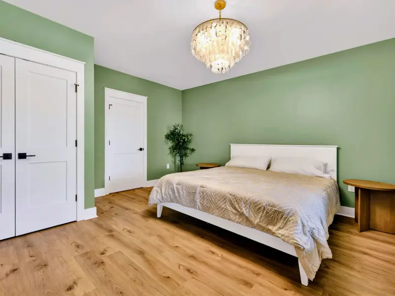 Lower King Suite - A king bed under a capiz chandelier anchors the walkout-level suite, calm and private just off the game room.
