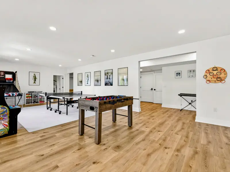 Game Room - The lower-level play zone runs from arcade and Pop-A-Shot to ping pong and foosball, with a keyboard tucked into the corner.