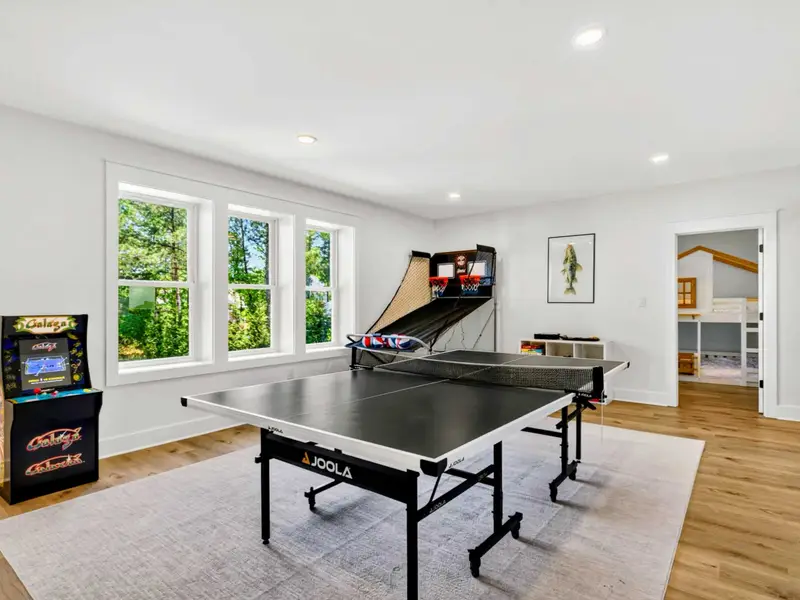 Game Room - JOOLA ping pong anchors the lower level alongside a Galaga arcade and Pop-A-Shot hoops, with a treehouse bunk room just around the corner.