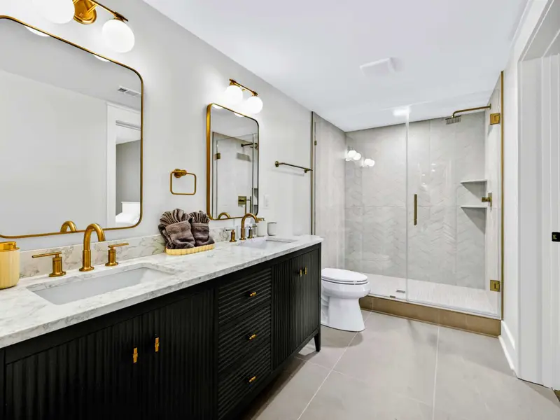 Lower Ensuite Bath - A double vanity, glass walk-in shower, and chevron tile make this lower-level bath feel like a true spa.