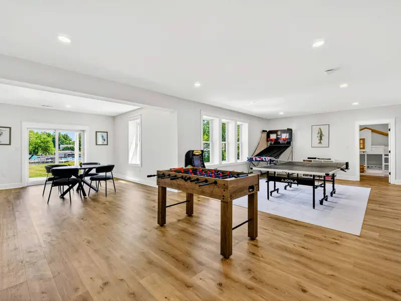 Game Room - The full lineup of foosball, ping pong, and arcade sits beside a lakeview dining nook, the lower level built for downtime.