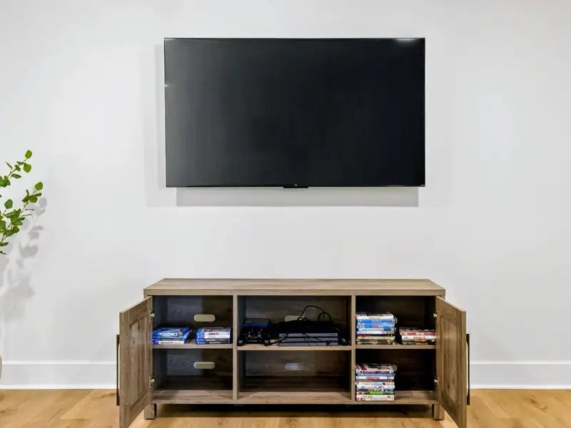 Movie Night Ready - The media console is stocked with a game console, controllers, and a stack of DVDs for easy rainy-day marathons.