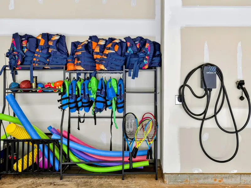 Gear Garage - Life jackets in every size, pool noodles, rackets, and a fishing rod stay ready here, alongside a Level 2 EV charger for your car.