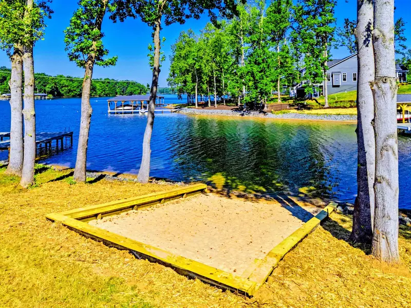 Private Beach - A real sand beach steps from the lake, framed and ready for towels, chairs, and afternoons in the water.