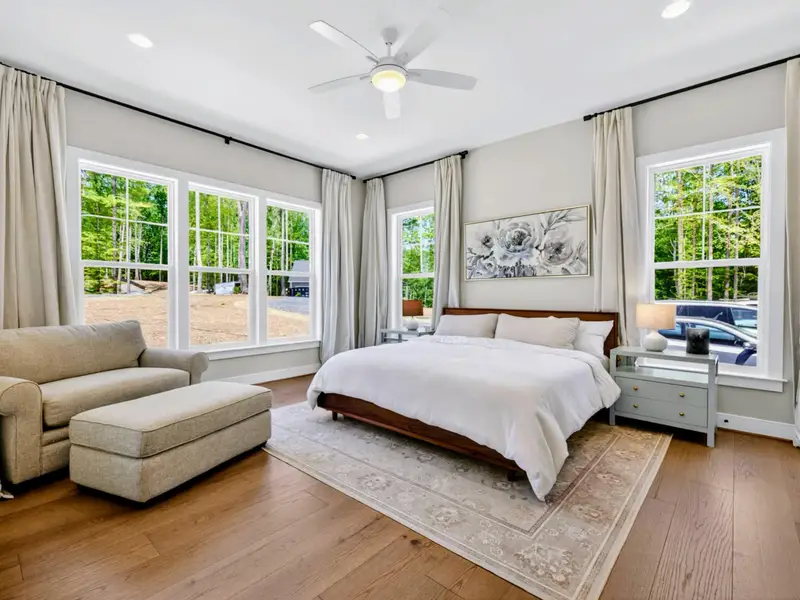 Bedroom - A wood-framed king with blackout curtains and soft natural light.
