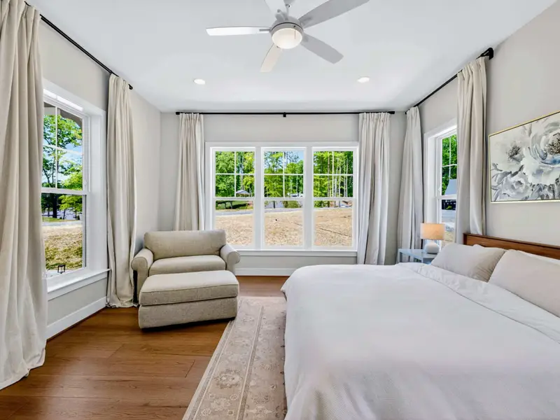 Bedroom - Crisp white linens, lake-facing windows, and a twin sleeper sofa in this calm main-level room.
