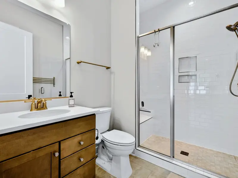 Full Bathroom - A wood vanity and glass walk-in shower keep this main-floor bath bright and clean.