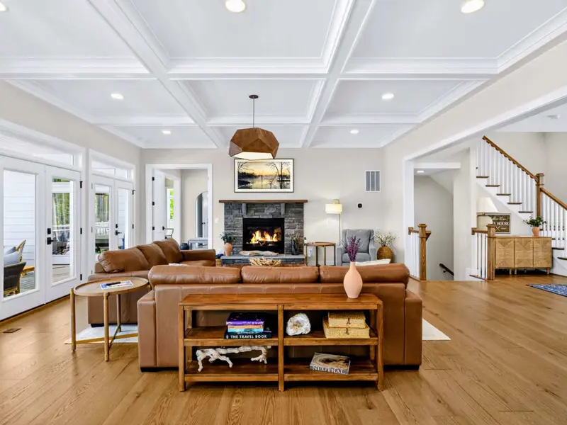Great Room - Sectionals styled with a book-filled console face the stone fireplace and Frame TV, flowing toward the staircase and a charming reading nook.
