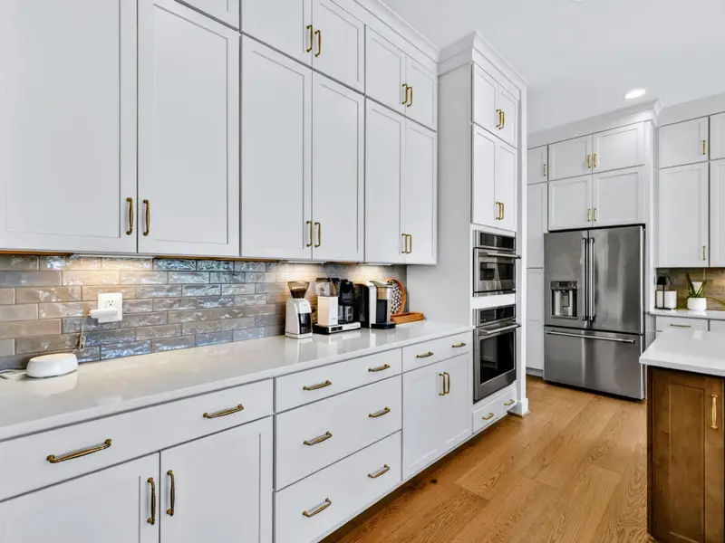 Kitchen - A built-in wall oven and ample cabinetry line the wall, with a second oven in the gas range.