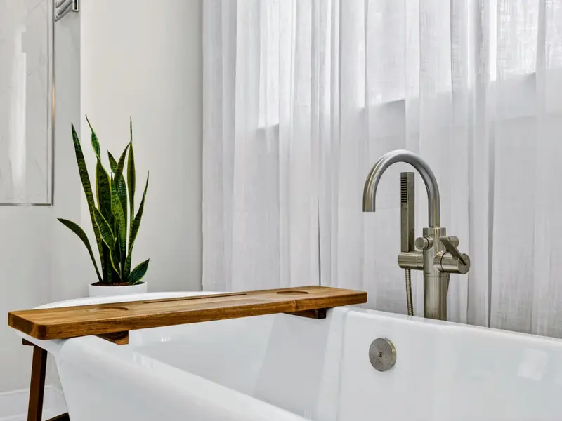 Primary Bath - A floor-mounted tub filler and teak caddy at the freestanding tub.