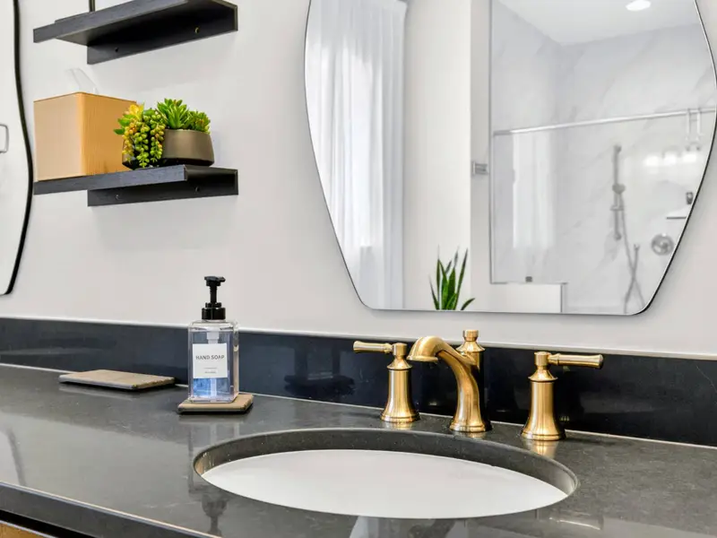 Primary Bath - An undermount sink and arched mirror over the stone counter.