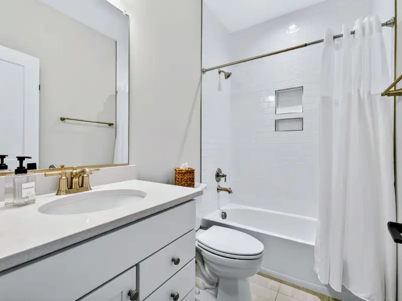 Full Bathroom - A single vanity and tiled tub-shower combo serve the upstairs bedrooms.