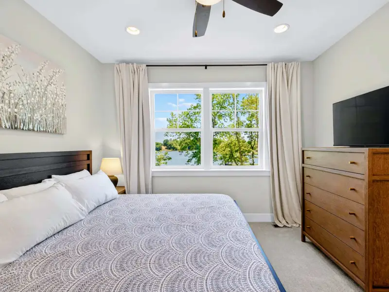 Bedroom - A king bed with a ceiling fan and a window framing lake views.