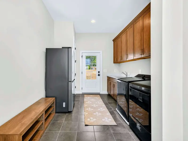 Laundry - Spacious side-by-side machines, a wood storage bench, and full-size refrigerator make this a handy drop zone off the entry.