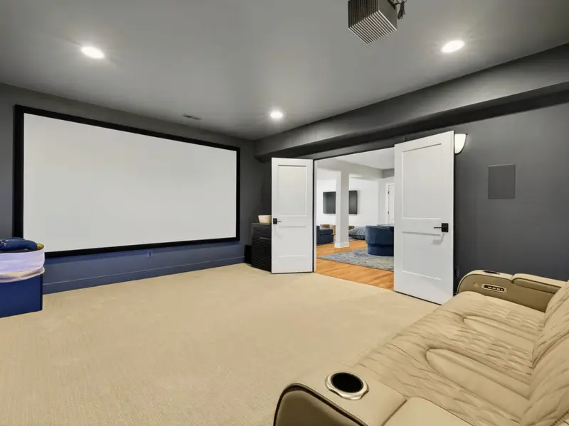Movie Theater - Two tiered rows of leather recliners face a wall-sized projector screen for true movie nights.