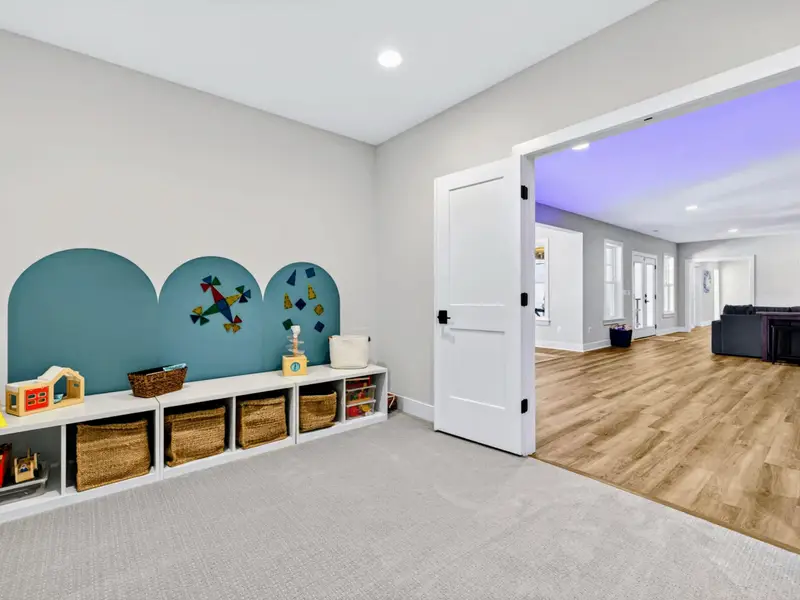 Kids' Playroom - A cheerful play space with cube storage, toys, and a blue magnet wall.