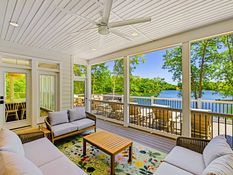 Screened Porch - Comfortable cushioned seating and a floral rug set the stage for relaxed afternoons overlooking the sparkling lake.