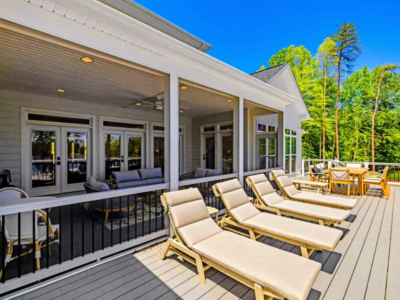 Deck - A row of chaise loungers and the dining set share this airy upper deck, blending sun and shade beside the covered porch.