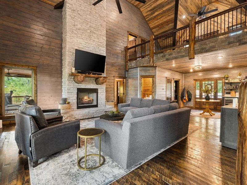 Experience rustic charm and modern coziness in our cabin's living room, complete with a inviting stone fireplace
