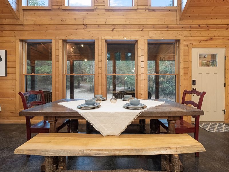 Enjoy your meals with a stunning forest backdrop, thanks to a wall of windows that brings the beauty of nature right to the dining table.