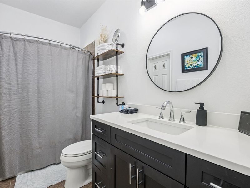 Bright and functional shared bathroom with modern fixtures and plenty of space for guests.