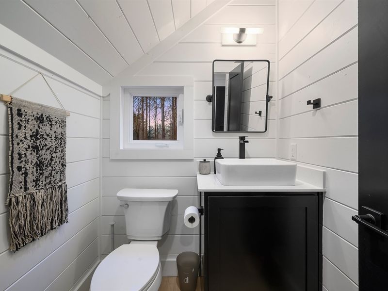 Compact yet beautifully appointed, this guest bathroom blends modern design with cozy cabin charm.