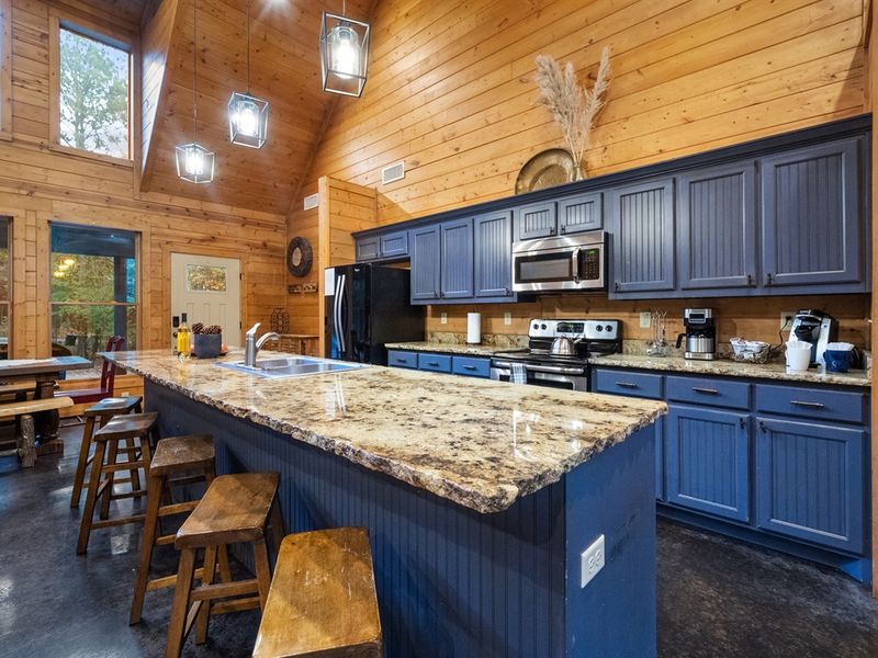 The spacious kitchen island is perfect for family meals or casual chats. With seating for five, it's the ideal spot to unwind after a day of adventure in Broken Bow.