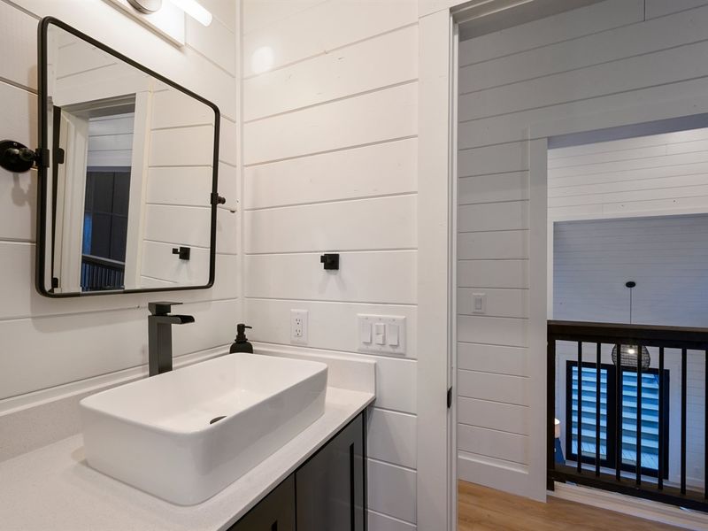 The contemporary vessel sink and matte black faucet create a bold, stylish statement.