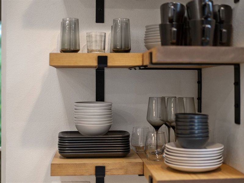 Glassware displayed on custom open shelving (additional plastic plates, bowls, and cups are provided in drawers)