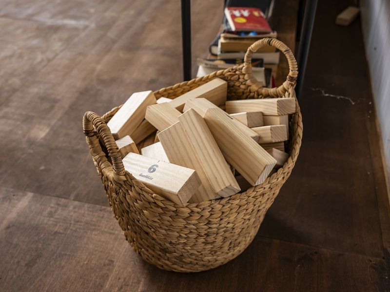 Basket filled with wooden blocks, showcasing a cozy interior setting, perfect for family fun