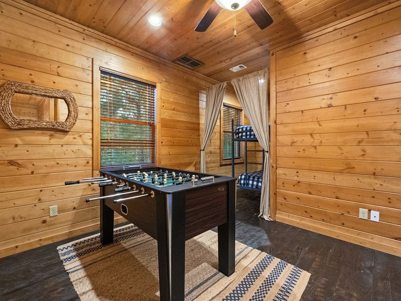 The upstairs cabin bunk room is designed for adventure, with hidden twin-over-twin bunks for restful nights and a foosball table for hours of fun—giving kids and teens their own space to unwind.