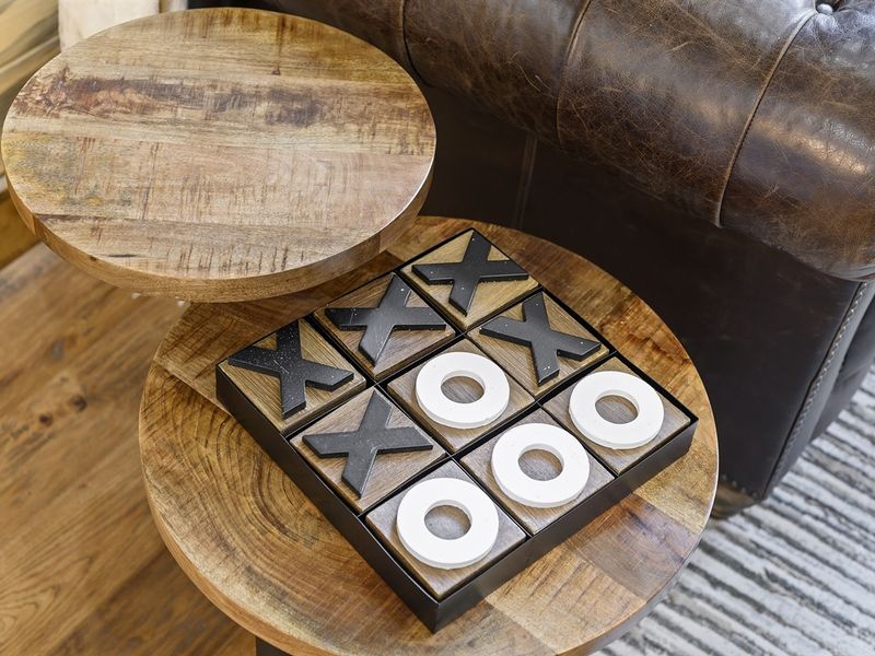 "A moment of pause, with a game of tic-tac-toe waiting quietly on the coffee table."