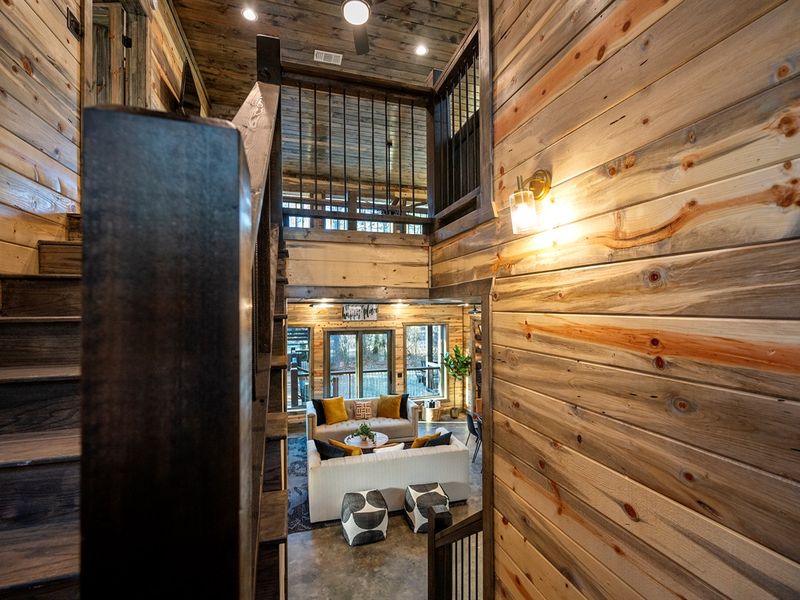 A stunning open view connects the staircase, upstairs loft, and inviting living room below.