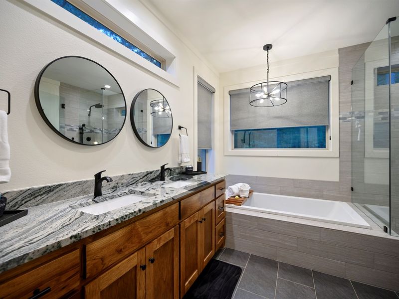 Your private spa retreat — soak in the deep tub, rinse in the glass shower, and unwind surrounded by warm wood and soft light.