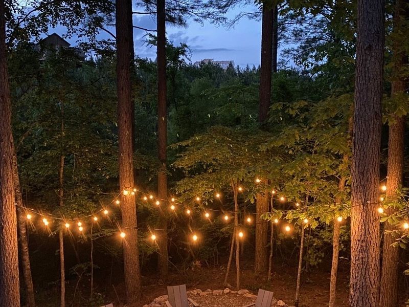 Warm lighting illuminates around the firepit.