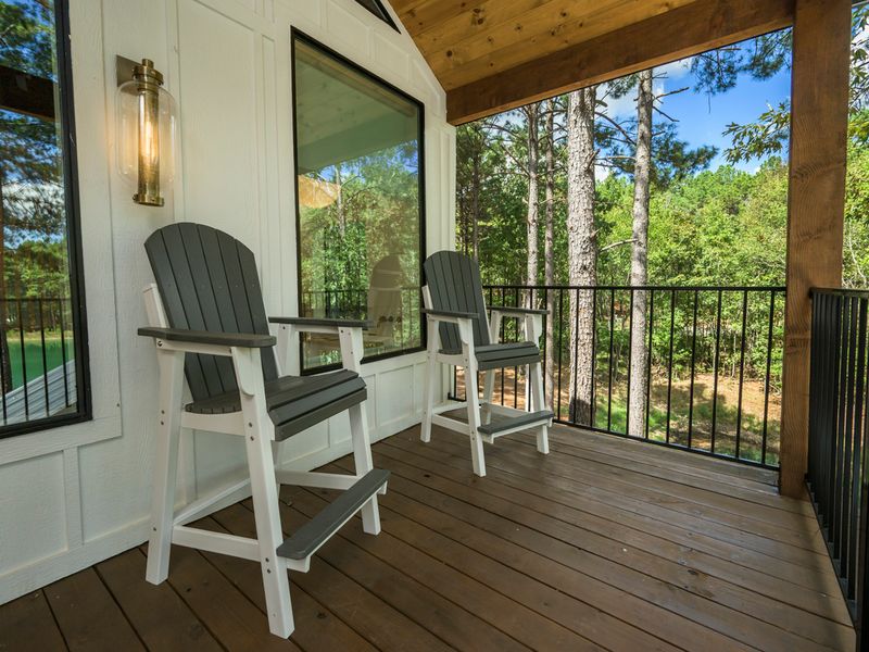 A peaceful covered deck offers comfortable seating and beautiful views of the surrounding pine forest, creating the perfect spot to relax and enjoy nature.