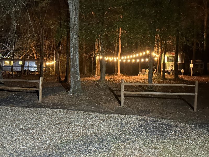Embrace the true spirit of outdoor living as your Airstream's secluded patio beckons with a inviting fire pit, offering the perfect setting for late-night chats and marshmallow-roasting adventures under the starry skies.