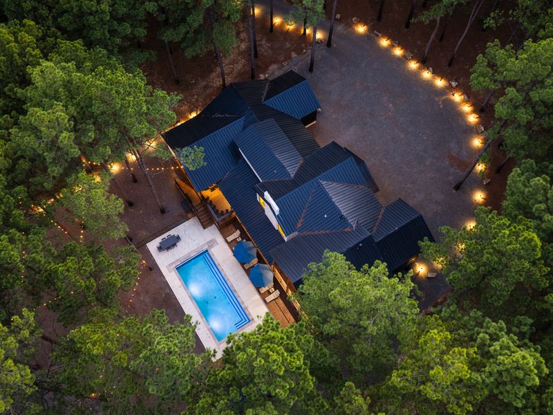 Aerial view of Bear Lake Lodge, a modern-rustic retreat nestled among towering pines, showcasing