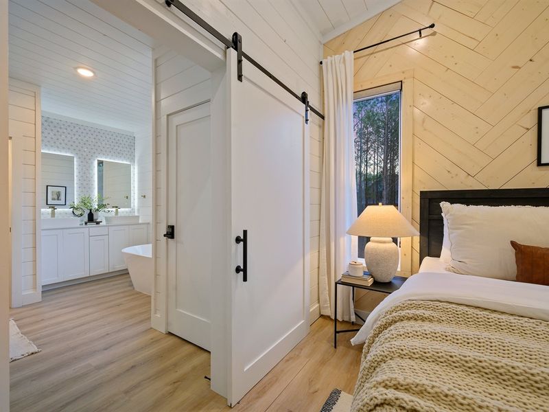 A stylish sliding barn door leads to the spa-inspired ensuite bathroom.