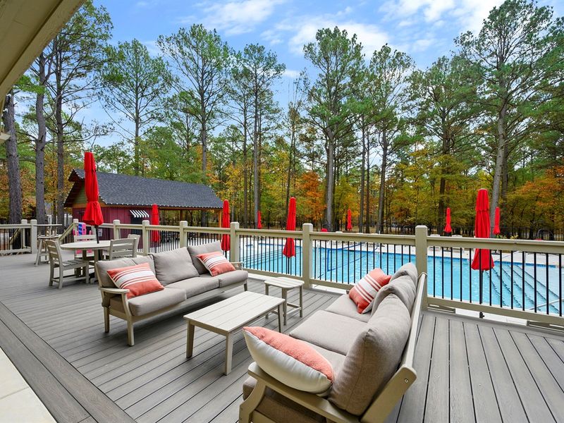 Spacious clubhouse pool area with plenty of lounge seating, shaded tables, and beautiful forest views—perfect for relaxing during your Broken Bow stay. 🏊‍♀️🌲✨