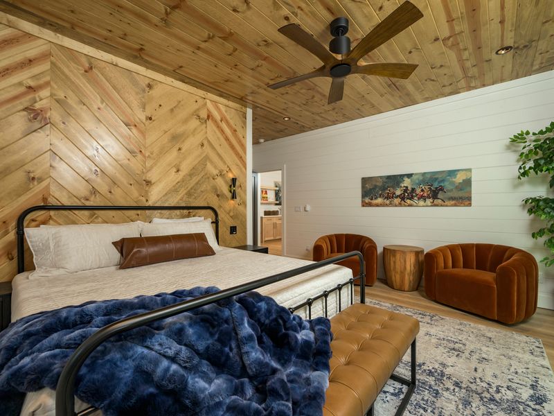 Settle into a beautifully designed bedroom where natural wood, soft linens, and rich blue accents create a warm and inviting place to unwind.