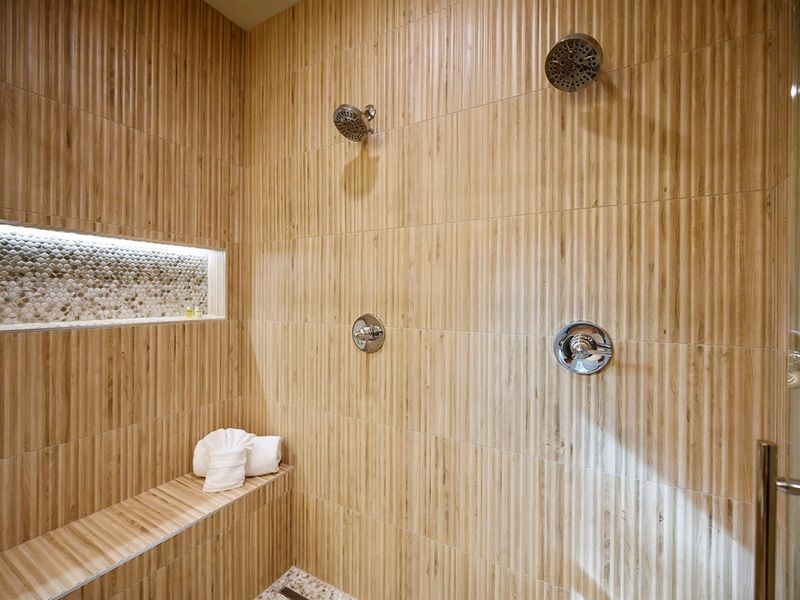 A spacious walk-in shower with calming tones and a cozy bench for the ultimate relaxation. 🤍🌿