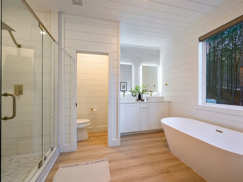 Crisp white shiplap walls and warm wood floors blend modern design with cabin charm.