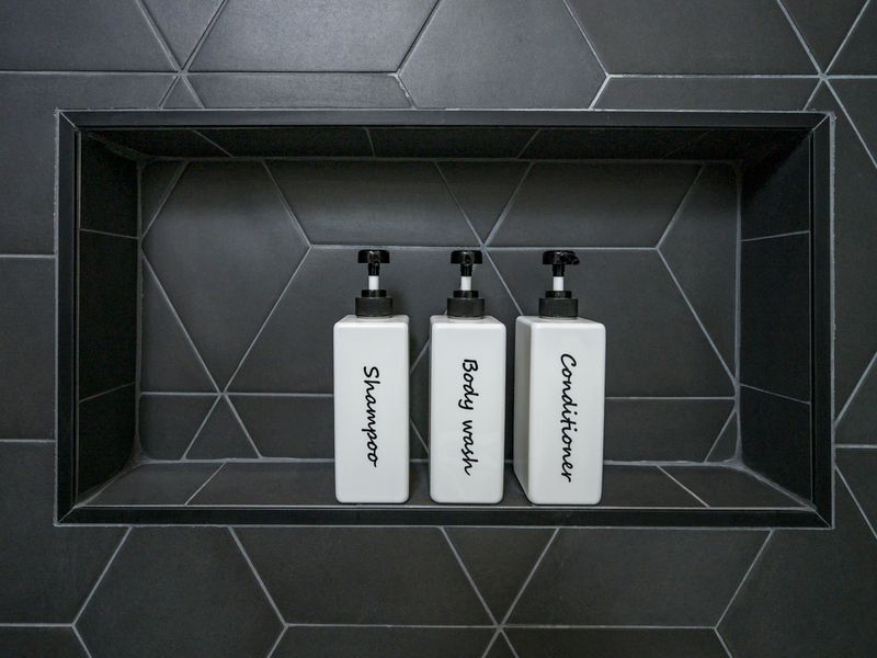 Convenient shower niche stocked with shampoo, body wash, and conditioner.