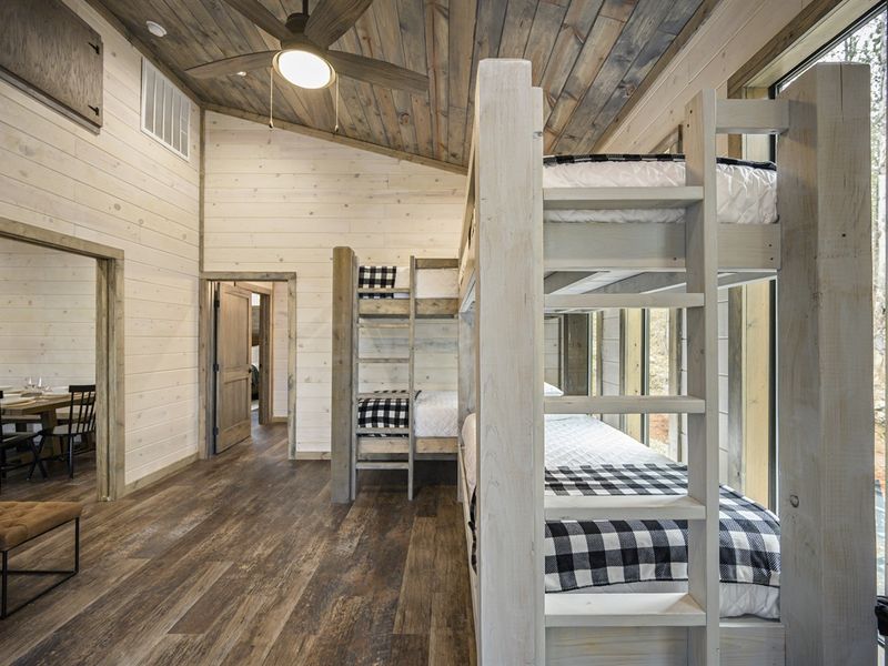 Get ready for a night of peaceful slumber in this inviting bunk bed nook. The wooden floors add warmth to this cozy corner in the cabin. Sweet dreams await!