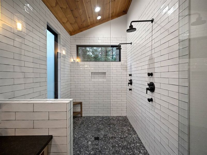 Walk-in shower with double rain shower heads, four additional body sprayers, and 9-ft. glass to keep heat in