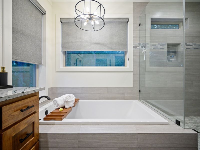 Luxury spa bathroom with soaking tub and glass walk-in shower — unwind in modern cabin comfort surrounded by forest serenity. Perfect for romantic Broken Bow getaways.