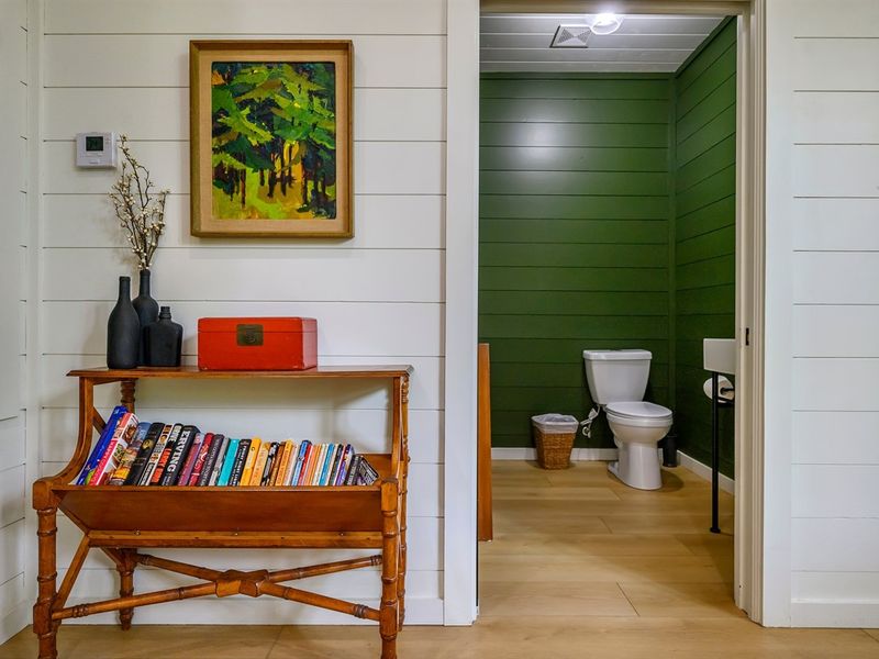 Adding a splash of literary charm to your bathroom! 📖💚 Dive into a good book surrounded by the invigorating green walls and convenient bookshelf in this stylish restroom sanctuary!